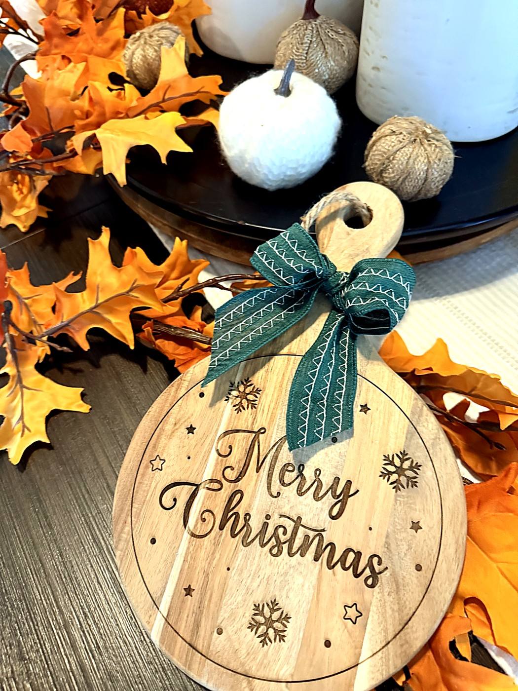 Round Merry Christmas engraved board with a green bow