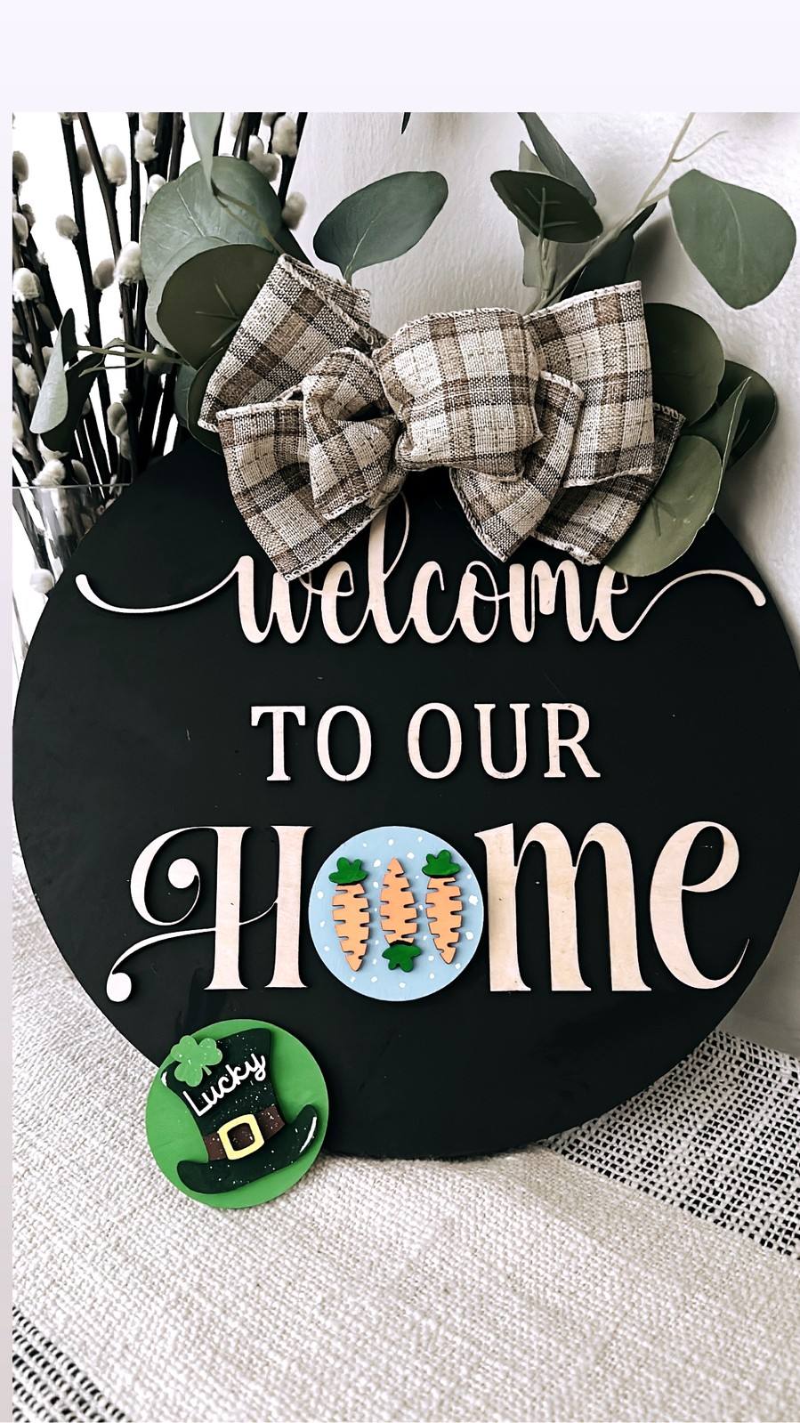 Round Welcome to our Home sign decorated with leaves