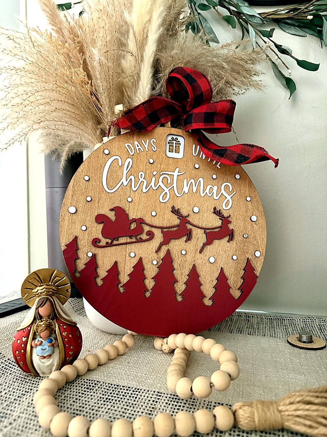 Days until Christmas round sign with Santa's sleigh and red trees