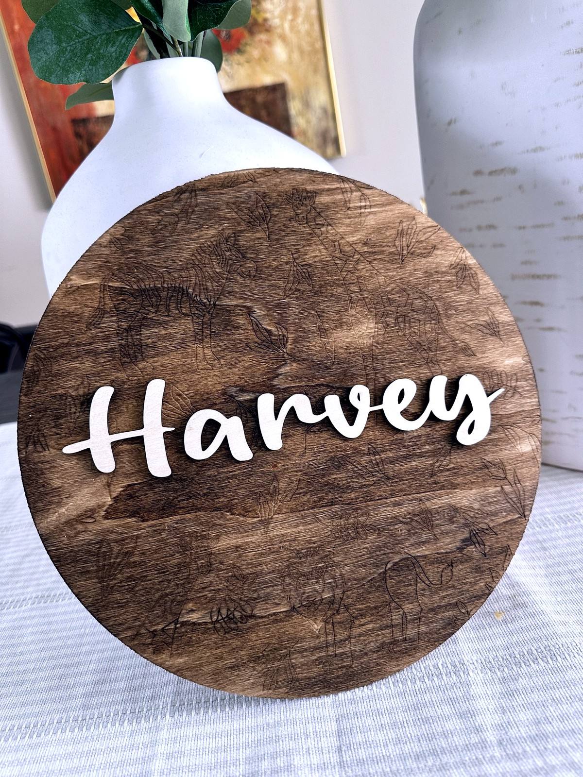 Round wooden sign personalized with the name Harveys