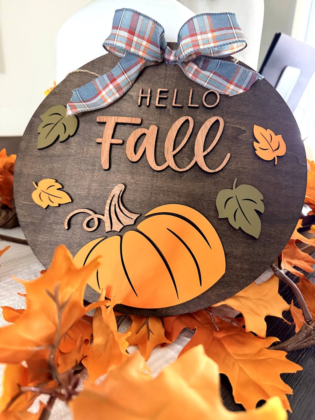 Round wooden Hello Fall sign with a pumpkin